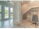 Sunlit entryway with tiled floors, front door, and adjacent office space with custom shelving at 8268 Bellow St, Orlando, FL 32827