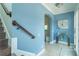 Bright foyer featuring light blue walls, tile flooring, and a staircase at 8268 Bellow St, Orlando, FL 32827