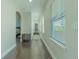 Bright hallway with hardwood floors, white trim, and natural light streaming through the window blinds at 8268 Bellow St, Orlando, FL 32827