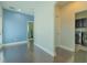 Hallway area featuring light blue accent wall, doorway leading to laundry area, and hardwood floors at 8268 Bellow St, Orlando, FL 32827