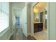 Bright hallway leading to a bathroom featuring dark wood cabinets and vanity with a decorative mirror at 8268 Bellow St, Orlando, FL 32827