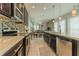 Modern kitchen showcasing dark wood cabinetry, tile backsplash, stainless steel appliances, and an open layout at 8268 Bellow St, Orlando, FL 32827