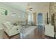 Comfortable living room with white sofas, wood floors, and large windows at 8268 Bellow St, Orlando, FL 32827