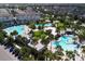 Aerial view of resort style community pools with palm trees, lounge chairs, and several pools and water features at 8268 Bellow St, Orlando, FL 32827
