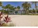 A beautiful community sand volleyball court surrounded by palm trees and lush landscaping at 8268 Bellow St, Orlando, FL 32827