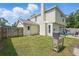 Spacious backyard with wood fencing, lush green grass, and convenient access door at 879 Matt Ln, Port Orange, FL 32127