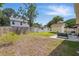 Large fenced backyard with a shed, patio seating, and lush green grass at 879 Matt Ln, Port Orange, FL 32127