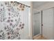 Bright bathroom with floral shower curtain, glass enclosed shower, and white door at 879 Matt Ln, Port Orange, FL 32127