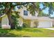 Charming yellow two-story home featuring a well-maintained front yard, arched window, and a two-car garage at 879 Matt Ln, Port Orange, FL 32127