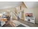 Open-concept living room with vaulted ceilings, wood floors, and a staircase leading to the second floor at 879 Matt Ln, Port Orange, FL 32127