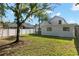 Backyard view showcasing the home's exterior, a lush lawn, and mature trees at 9987 Triple Crown Cir, Orlando, FL 32825