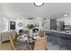 Open-concept dining area with a round glass table, wicker chairs, and seamless connection to the kitchen at 9987 Triple Crown Cir, Orlando, FL 32825