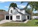 Charming two-story home features a black roof, white siding, black garage doors and manicured lawn at 9987 Triple Crown Cir, Orlando, FL 32825
