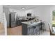 Bright kitchen with stainless steel appliances, gray cabinets, quartz countertop and breakfast bar seating at 9987 Triple Crown Cir, Orlando, FL 32825