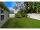 Well-maintained backyard with green grass, privacy fence, and tropical plants at 1012 Marisol Ct, Orlando, FL 32828