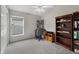 Well-lit bedroom with a desk, chair, bookcase, and neutral carpet at 1012 Marisol Ct, Orlando, FL 32828