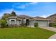 A well-manicured front yard leads to this home with a two-car garage and neutral paint scheme at 1012 Marisol Ct, Orlando, FL 32828