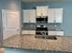 Well-lit kitchen features granite countertops, white cabinets, and modern stainless steel appliances at 10126 Beach Port Dr, Winter Garden, FL 34787