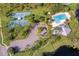Aerial view of the community recreational center featuring a pool, tennis courts and mature trees at 10143 Pink Carnation Ct, Orlando, FL 32825