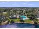 Aerial view of the community featuring a clubhouse, pool, tennis courts, and lush landscaping by the lake at 10143 Pink Carnation Ct, Orlando, FL 32825