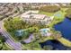 Aerial view of a school near a recreational center with tennis courts, a pool, and a lake at 10143 Pink Carnation Ct, Orlando, FL 32825