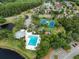 Aerial view highlighting a community pool, clubhouse, playground and tennis courts with mature trees at 10143 Pink Carnation Ct, Orlando, FL 32825