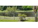 Backyard view featuring an iron fence and pond with mature trees at 10143 Pink Carnation Ct, Orlando, FL 32825