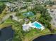 Overhead shot of the pool, tennis courts, and clubhouse, all surrounded by mature landscaping and homes at 10143 Pink Carnation Ct, Orlando, FL 32825