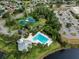 Aerial view of tennis courts, a pool, and a clubhouse set amidst lush trees in the community at 10143 Pink Carnation Ct, Orlando, FL 32825