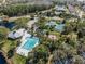 Aerial view of a community pool, clubhouse, playground, tennis courts, and pond surrounded by lush landscaping at 10143 Pink Carnation Ct, Orlando, FL 32825