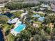 Aerial view of a community pool, clubhouse, playground, tennis courts, and pond surrounded by lush landscaping at 10143 Pink Carnation Ct, Orlando, FL 32825