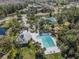 Aerial view of a community pool, clubhouse, playground, tennis courts, and pond surrounded by lush landscaping at 10143 Pink Carnation Ct, Orlando, FL 32825