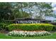 Well-maintained entrance to Cypress Springs, featuring lush landscaping and vibrant flowers at 10143 Pink Carnation Ct, Orlando, FL 32825
