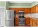 Efficient kitchen layout with stainless steel appliances and stylish wooden cabinetry at 10143 Pink Carnation Ct, Orlando, FL 32825