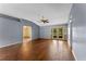 Open-concept living room with hardwood floors, neutral paint, and access to the screened-in porch at 10143 Pink Carnation Ct, Orlando, FL 32825