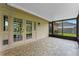 Covered patio with tile flooring, screened windows and double doors leading to the house at 10143 Pink Carnation Ct, Orlando, FL 32825