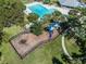 Aerial view of a playground and pool, with palm trees and lush landscaping around a lake at 10143 Pink Carnation Ct, Orlando, FL 32825