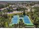 Aerial view of tennis courts featuring central gazebo with neighborhood street and trees in the background at 10143 Pink Carnation Ct, Orlando, FL 32825