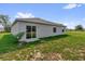 An outside view of the backyard featuring grass and access to the house through sliding glass doors at 123 Zinnia W Ln, Poinciana, FL 34759