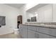 Bathroom featuring double sinks, gray cabinets, and a granite countertop at 123 Zinnia W Ln, Poinciana, FL 34759