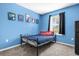 Bedroom with blue walls, a gray carpet, black curtains, and a bed with colorful pillows at 123 Zinnia W Ln, Poinciana, FL 34759