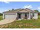 Charming single-story home with a gray exterior, inviting front porch, and well-manicured lawn at 123 Zinnia W Ln, Poinciana, FL 34759