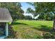 Spacious backyard featuring lush green grass, mature trees, and a view of the golf course at 125 W Wyndham Ct, Longwood, FL 32779