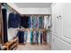 Organized walk-in closet with clothing racks, shelves and neutral tile flooring at 125 W Wyndham Ct, Longwood, FL 32779