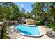 Beautiful community pool surrounded by lush landscaping with a cabana nearby at 125 W Wyndham Ct, Longwood, FL 32779