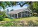 Rear exterior view of the home featuring a large screened-in porch and well-maintained landscaping at 125 W Wyndham Ct, Longwood, FL 32779