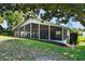 A view of the covered, screened porch on the back of this bright home with manicured landscaping at 125 W Wyndham Ct, Longwood, FL 32779