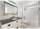 Bathroom featuring a white vanity with dark countertops, framed mirror, and tiled shower at 13169 Odyssey Lake Way, Orlando, FL 32826