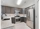 Modern kitchen featuring stainless steel appliances, granite countertops, and stylish gray cabinetry at 13169 Odyssey Lake Way, Orlando, FL 32826