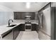 Modern kitchen with stainless steel appliances, granite countertops, and dark cabinets at 13169 Odyssey Lake Way, Orlando, FL 32826